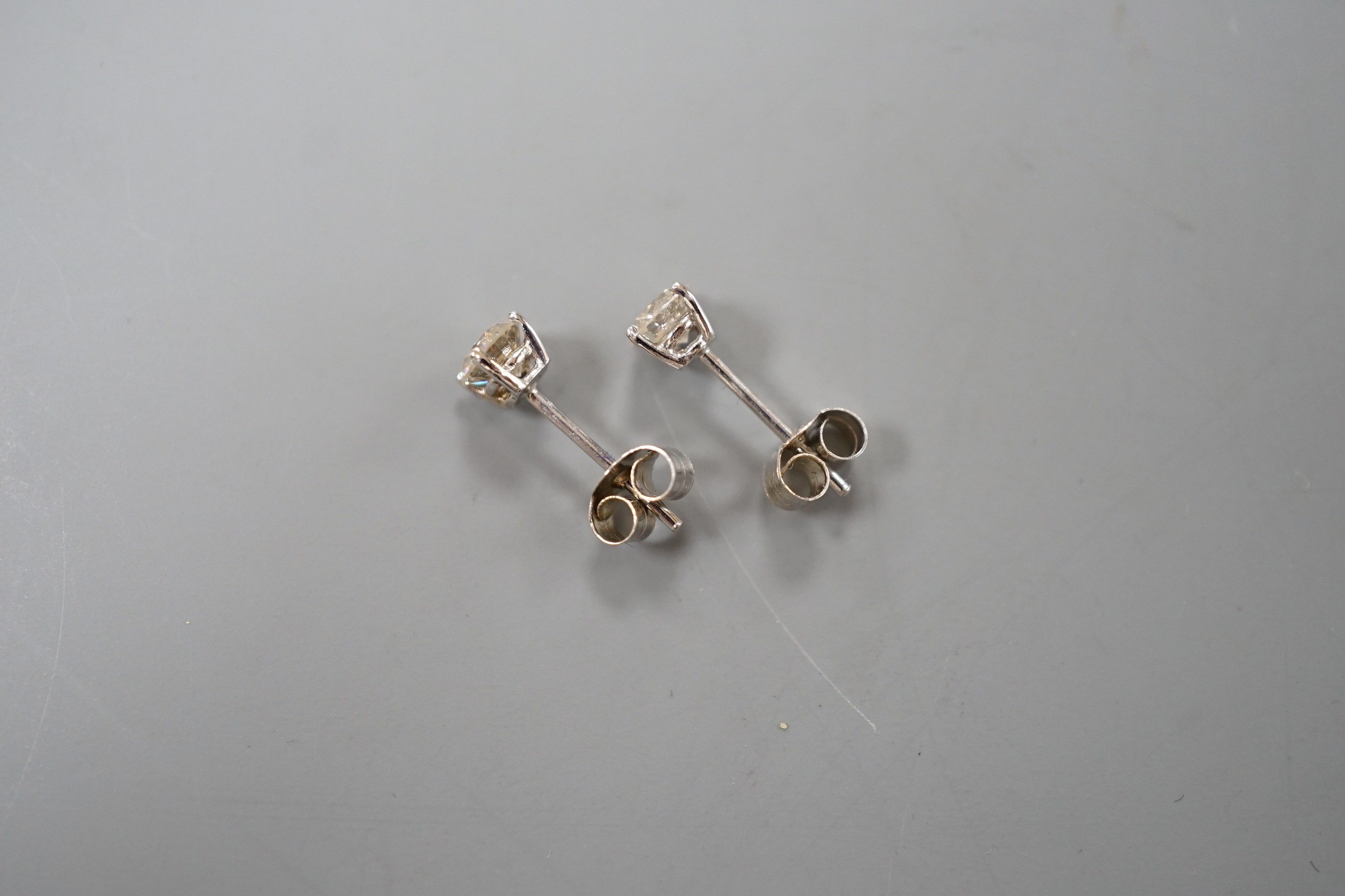 A pair of white metal and solitaire diamond set ear studs, gross weight 0.8 grams, stone diameter approx. 3.5mm.